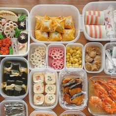 plastic containers filled with different types of food on top of a wooden table next to utensils