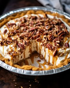 a pie with pecans and caramel drizzled on it's crust