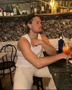 a man sitting at a table with a drink in front of him