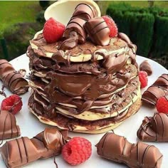 a large stack of chocolate cake with raspberries on top