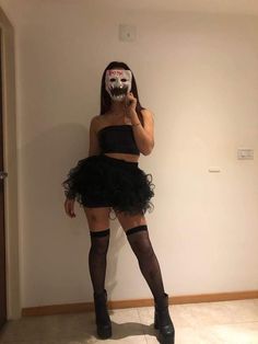 a woman wearing a mask and black dress