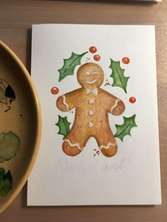 a painting of a ginger with holly leaves on it next to a bowl of paint