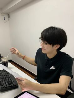 a person sitting at a desk with a computer and tablet in front of them,