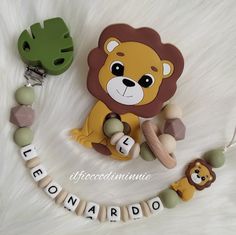 a lion pacifier and teethpick set on a white fur background