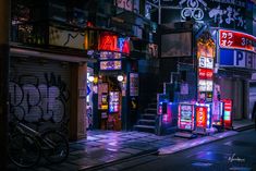 a city street at night with neon signs