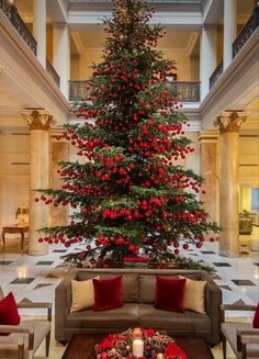 a christmas tree is in the middle of a large room with couches and tables