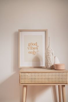 a white vase sitting on top of a wooden table next to a framed photograph and small vase