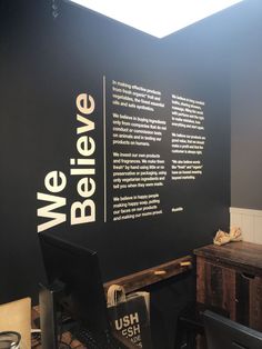 a black wall with white writing on it and a desk in front of the wall