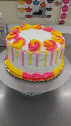 a white cake with pink and yellow icing