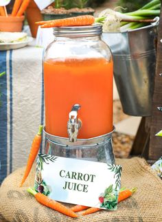 carrot juice is in a glass jar on a burlock with a sign that says carrot juice