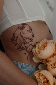 a close up of a woman's stomach with flowers in front of her belly