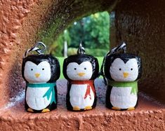 three little penguin figurines are sitting on a ledge