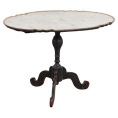 an old wooden table with white marble top and black metal legs, against a white background