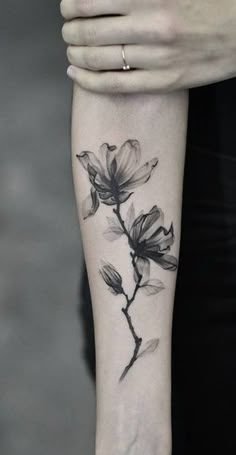 a woman's arm with a flower tattoo on it