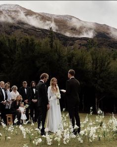 a bride and groom are standing in the middle of a field surrounded by white flowers