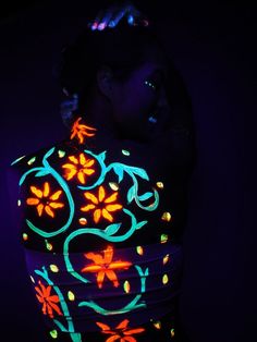 a woman wearing a colorful light up top with flowers on it's chest and arms