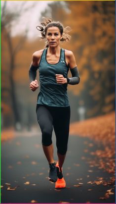 a woman running down a road with trees in the background and leaves on the ground