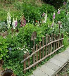 a wooden fence surrounded by lots of flowers