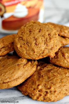 several cookies stacked on top of each other with a can of milk in the background