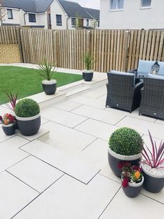 an outdoor patio with potted plants and chairs