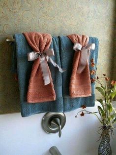 two towels hanging on the side of a sink