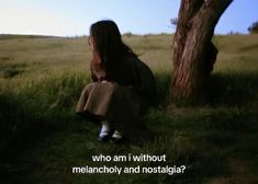 a woman sitting under a tree with the words who am i without melancholy and nostalia?