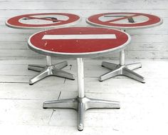 three red and white signs sitting on top of each other in front of a wooden floor