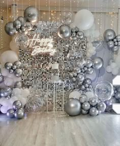 a room filled with silver and white balloons