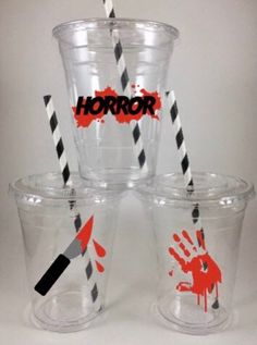 four plastic cups with black and red straws in them, one has a hand print on it