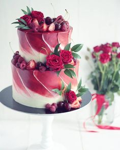 a three layer cake decorated with roses and cherries