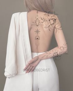 the back of a woman's body with tattoos on her upper and lower half