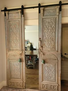 an old door is opened to reveal a dining room with a table and chairs in the background