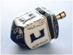 a blue and white ceramic object with gold trimmings on the sides, sitting on top of a table