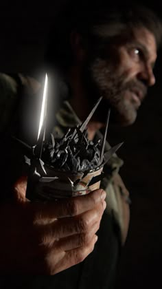 a man holding a knife and some sort of object in his hand with the light shining on him