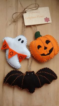 two halloween decorations hanging on a wooden table