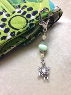 a close up of a keychain with a turtle charm on it's side