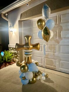 a large cross made out of balloons in front of a garage with a light on