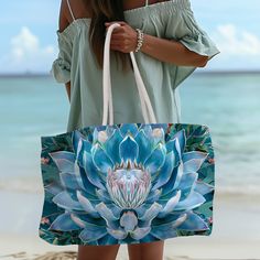 a woman holding a blue flower bag on the beach