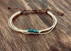 two white and blue bracelets sitting on top of a wooden table