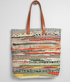 a multicolored tote bag hanging on a wall