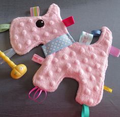 a pink stuffed animal laying on top of a table next to a toy rakel