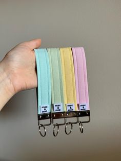 a hand is holding four different colored straps