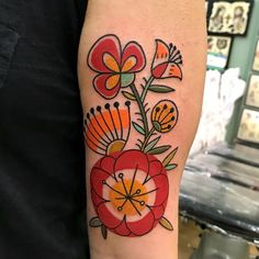 a colorful flower tattoo on the arm