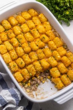 a casserole dish filled with tater tots and garnished with parsley