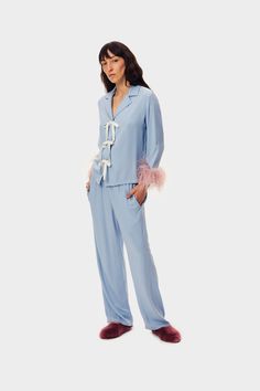 Relaxed pajama shirt and pants set in soft blue certified viscose. The shirt has a dropped shoulder and hip length, adorned with a contrasting satin bow closure and detachable ostrich feather cuffs. With a straight silhouette, the pants feature a comfortable elastic waistband and cropped hem. Designed for wearing from bed to brunch, and beyond. Feather Cuffs, Bow Women, Comfortable Pants, Pajama Dress, Ostrich Feather, Sleepwear & Loungewear, Blue Bow, Pajama Set Women, Satin Bow