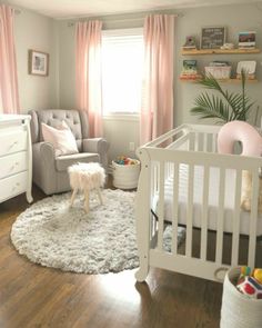 a baby's room with a white crib and pink curtains