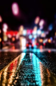 blurry image of city street at night with lights and buildings in the back ground