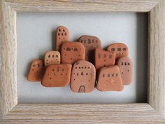 a group of rocks sitting in a frame on top of a table next to each other