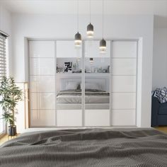 a bedroom with mirrored closet doors and a bed in the foreground, next to a couch