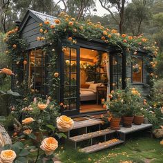 a small house with flowers growing on the roof and steps leading up to it's front door